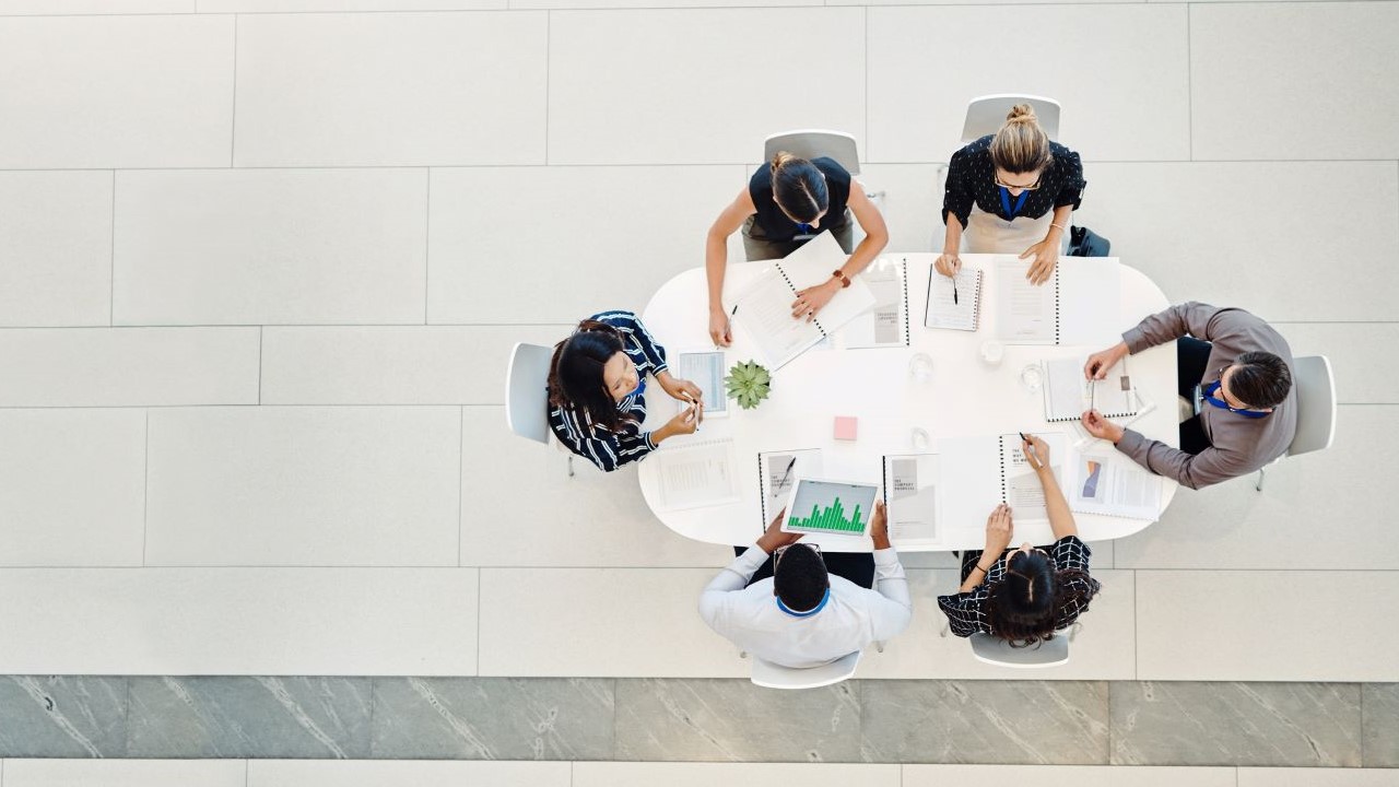 photo of a group of professionals meeting around a table from above